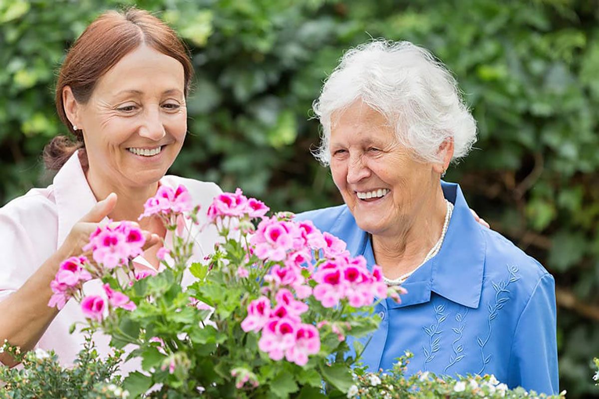 Apple Valley Place Two Women Looking At A Garden - Respite Care At Apple Valley Place